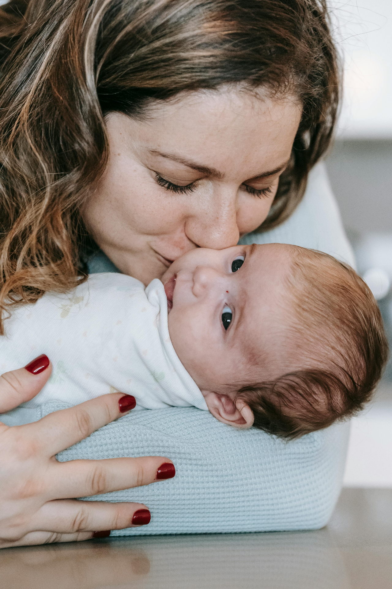 Mother kissing her newborn